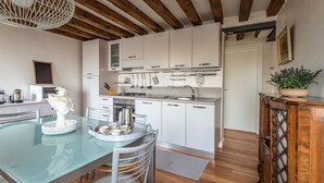A modern kitchen with white cabinets, a glass dining table, and a wooden ceiling. - Venezia - Calle Furlani 3277 (Venice)