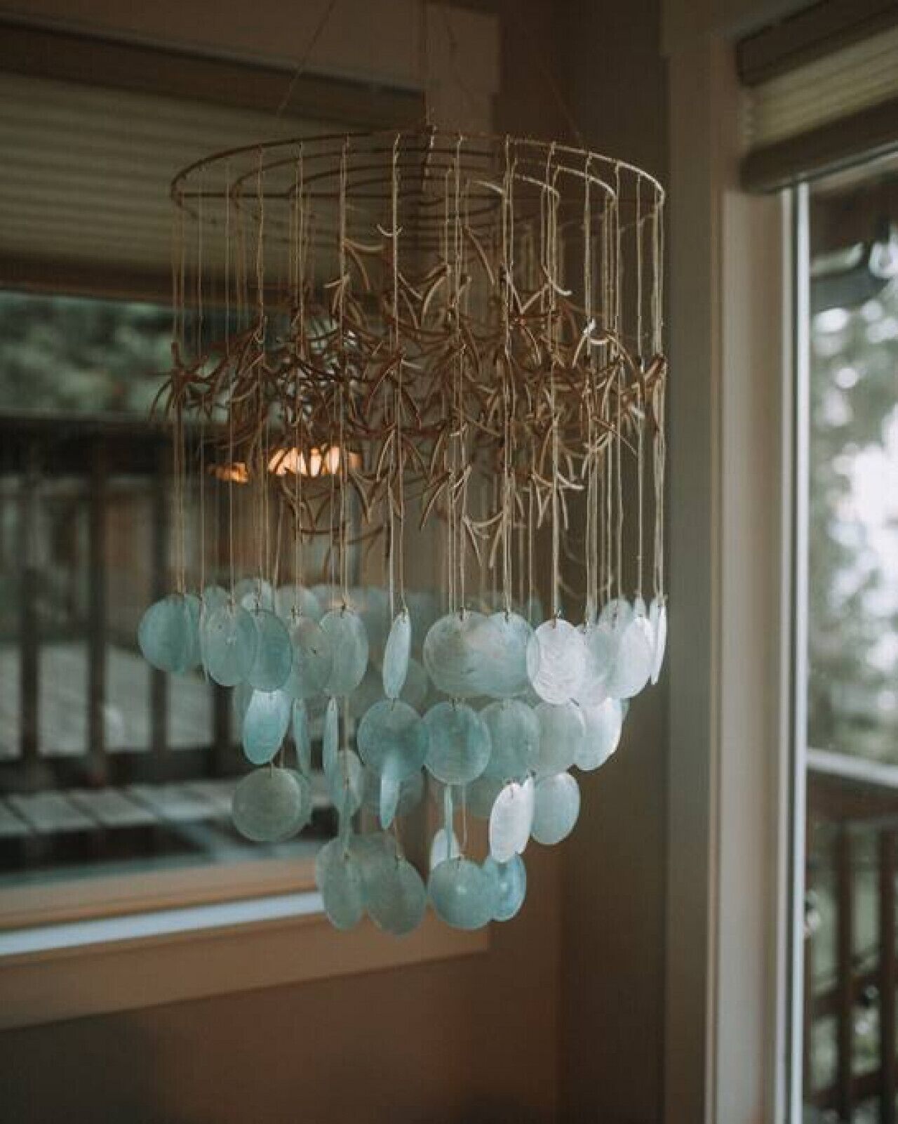 A chandelier with a unique design featuring hanging branches and spherical glass elements.