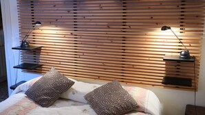 A bedroom with a wooden slat headboard, two bedside lamps, and patterned pillows. - Venezia - Calle De Le Vele (Venice)