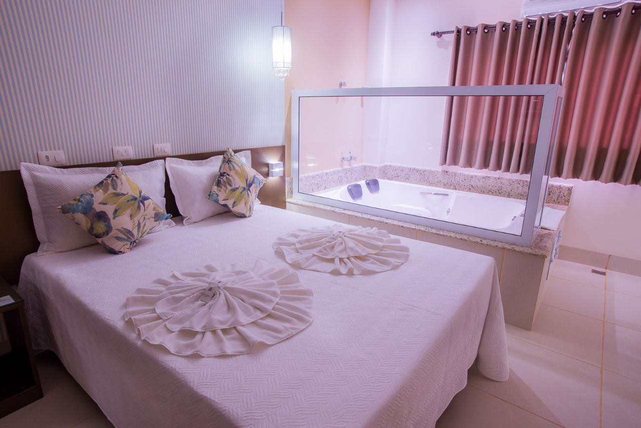 Habitación de hotel con cama, un espejo grande y vistas a un área de spa.