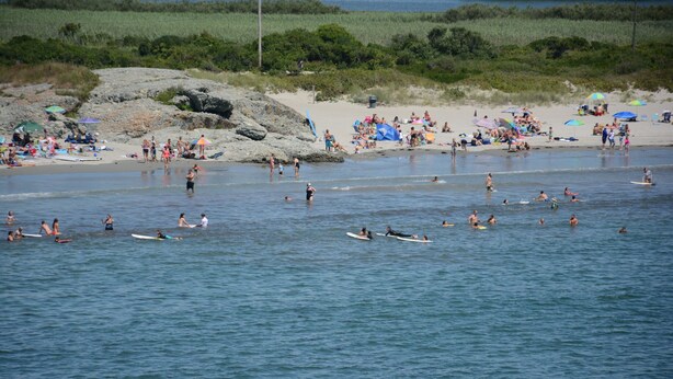 A beach with people swimming and surfing. - Perfect For Wedding Guest, Friends Getaway Or Family Vacation (Middletown)