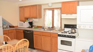 A compact kitchen with wooden cabinets, a microwave, a stove, and a dishwasher. - Perfect For Wedding Guest, Friends Getaway Or Family Vacation (Middletown)