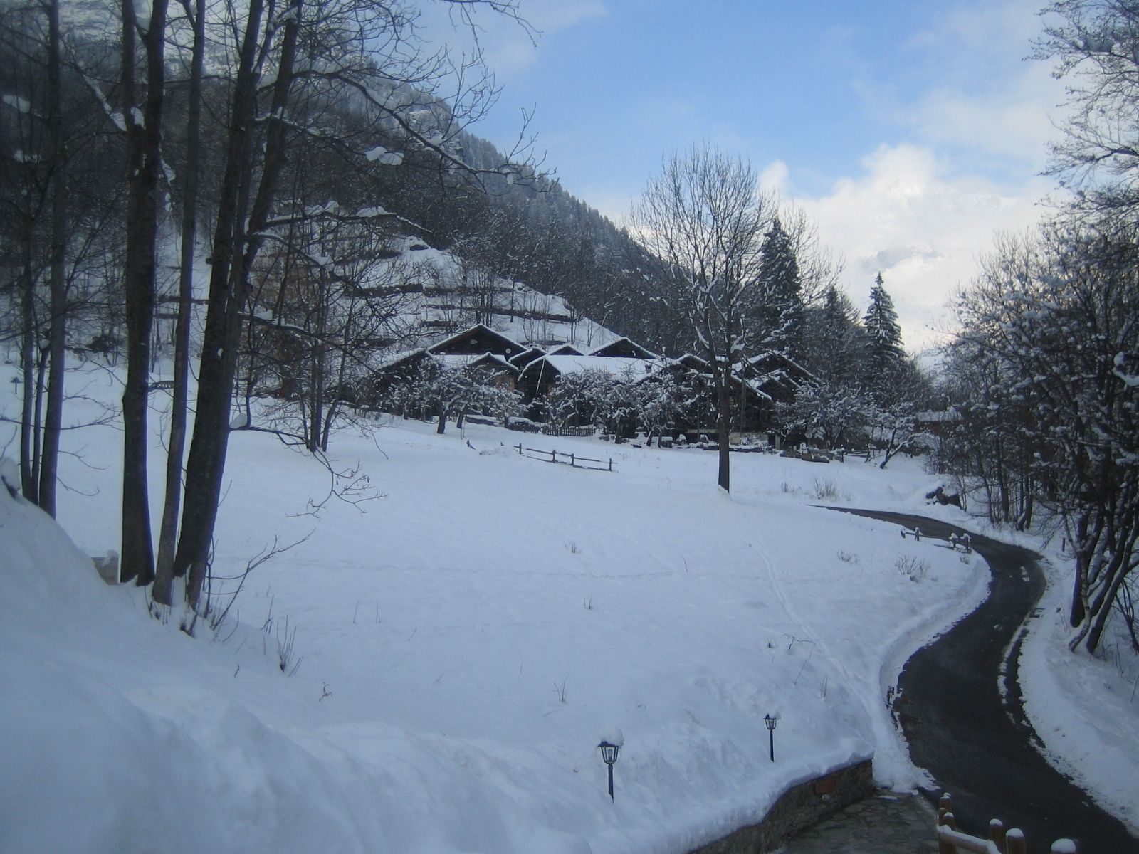 A snow-covered landscape with a wooden cabin and a winding path.