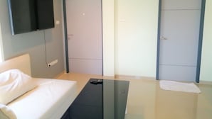 A modern hotel room with a bed, a flat-screen TV mounted on the wall, and two doors. - 3BRs 5 BathRms with private pool in BKK, 3 km to metro ,9 km to BKK airport (Bangkok)