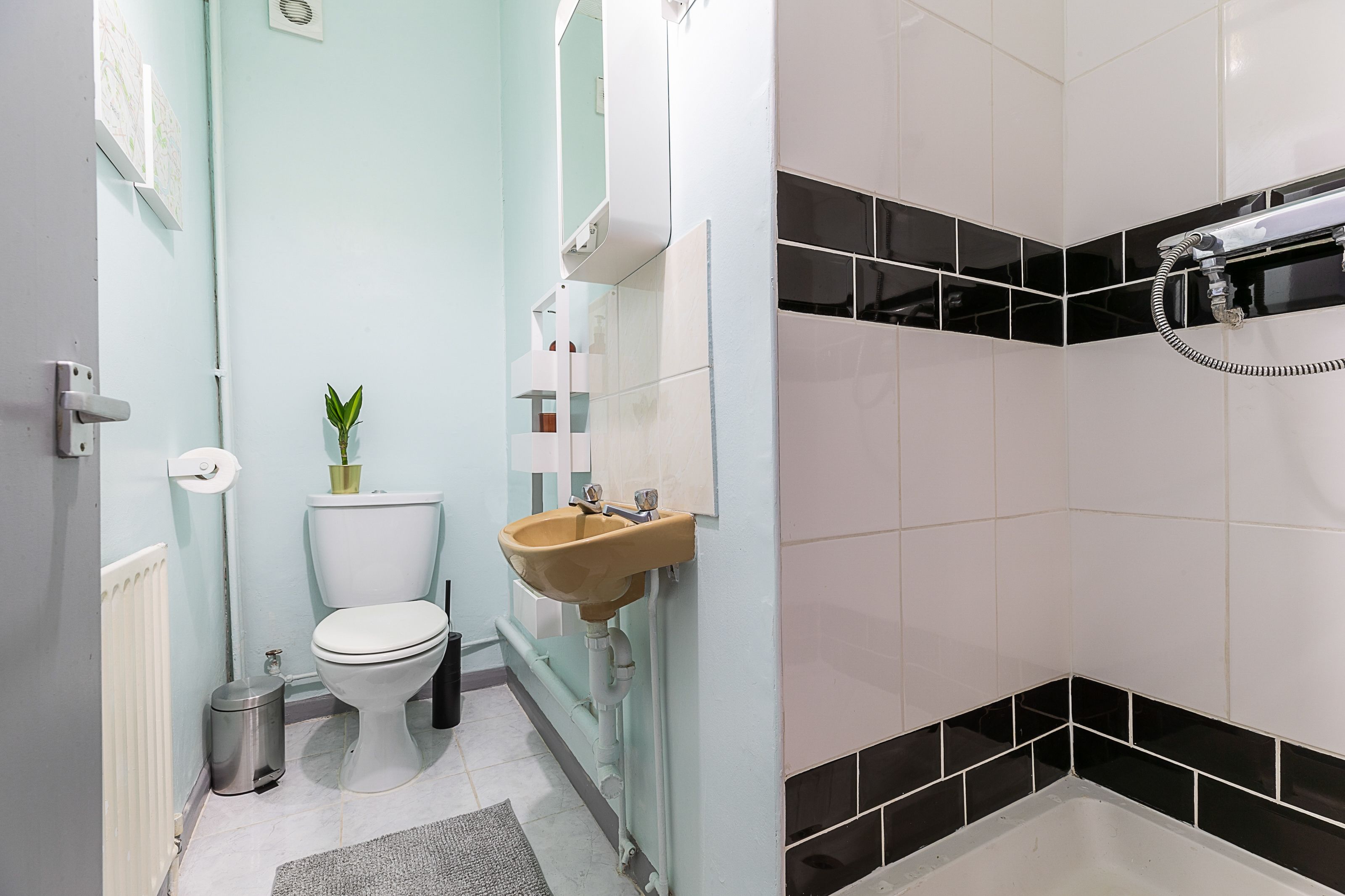 Une salle de bain avec des toilettes, un lavabo et une douche.