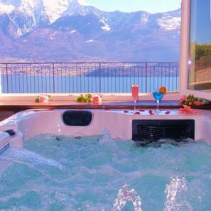 A hot tub with a view of a mountain lake and mountains. - Hotel Mojito (Domaso)