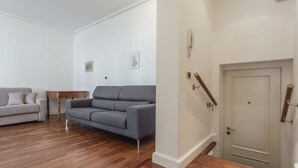 A living room with a grey sofa, a white sofa, and a wooden coffee table. - Venezia - San Pantalon 3700 (Venice)