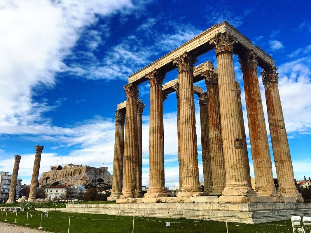 Ancient Greek columns with a clear view of the Acropolis in the background.