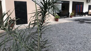 Un bâtiment doté d’un escalier, de plantes en pot et d’un espace extérieur aménagé pour s’asseoir.