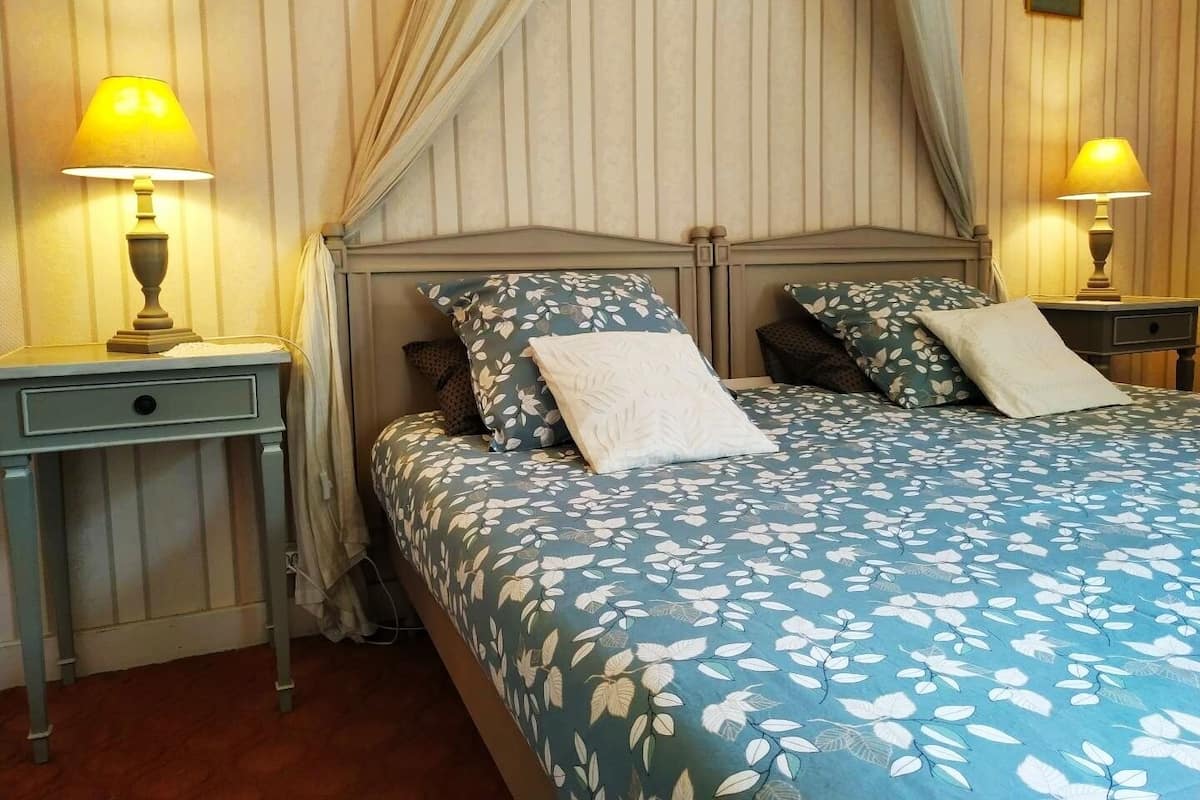 A neatly arranged bedroom with a bed, two bedside tables, and a nightstand.