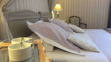 Une chambre d’hôtel avec un lit, une table de chevet avec un plateau, une lampe et une chaise.