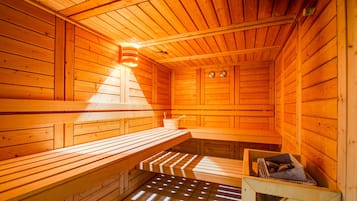 A sauna with wooden benches and a bench with a towel.