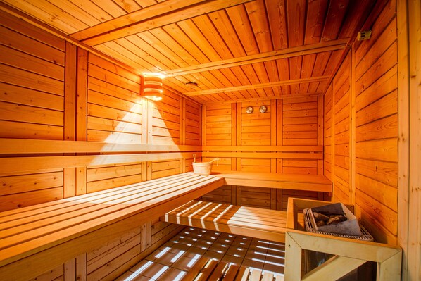 Una sauna con bancos de madera y un banco con toalla.