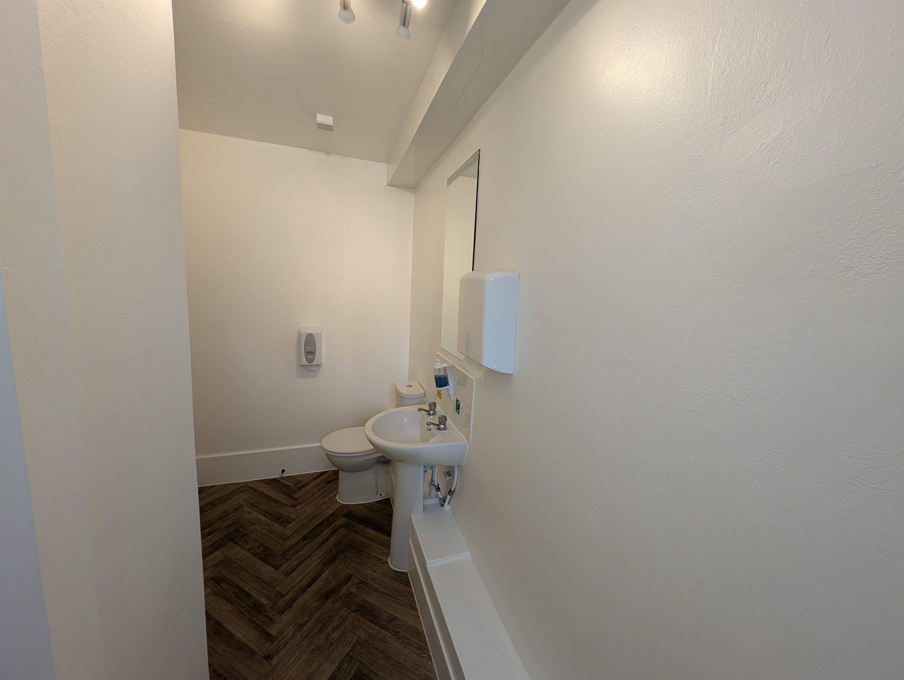 Ein Badezimmer mit Toilette, Waschbecken und Spiegel.