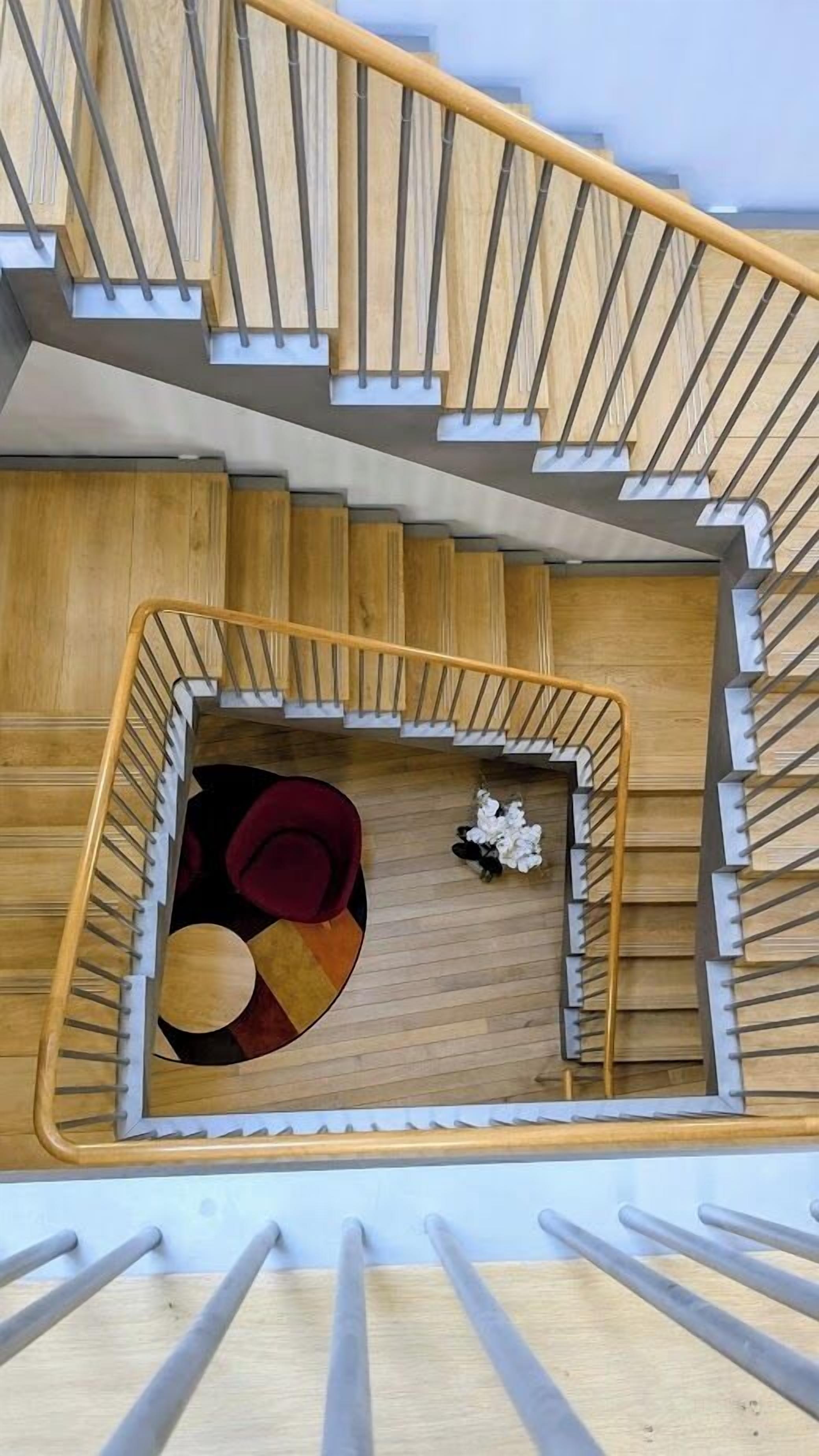 A wooden staircase with a railing, leading to a lower level.