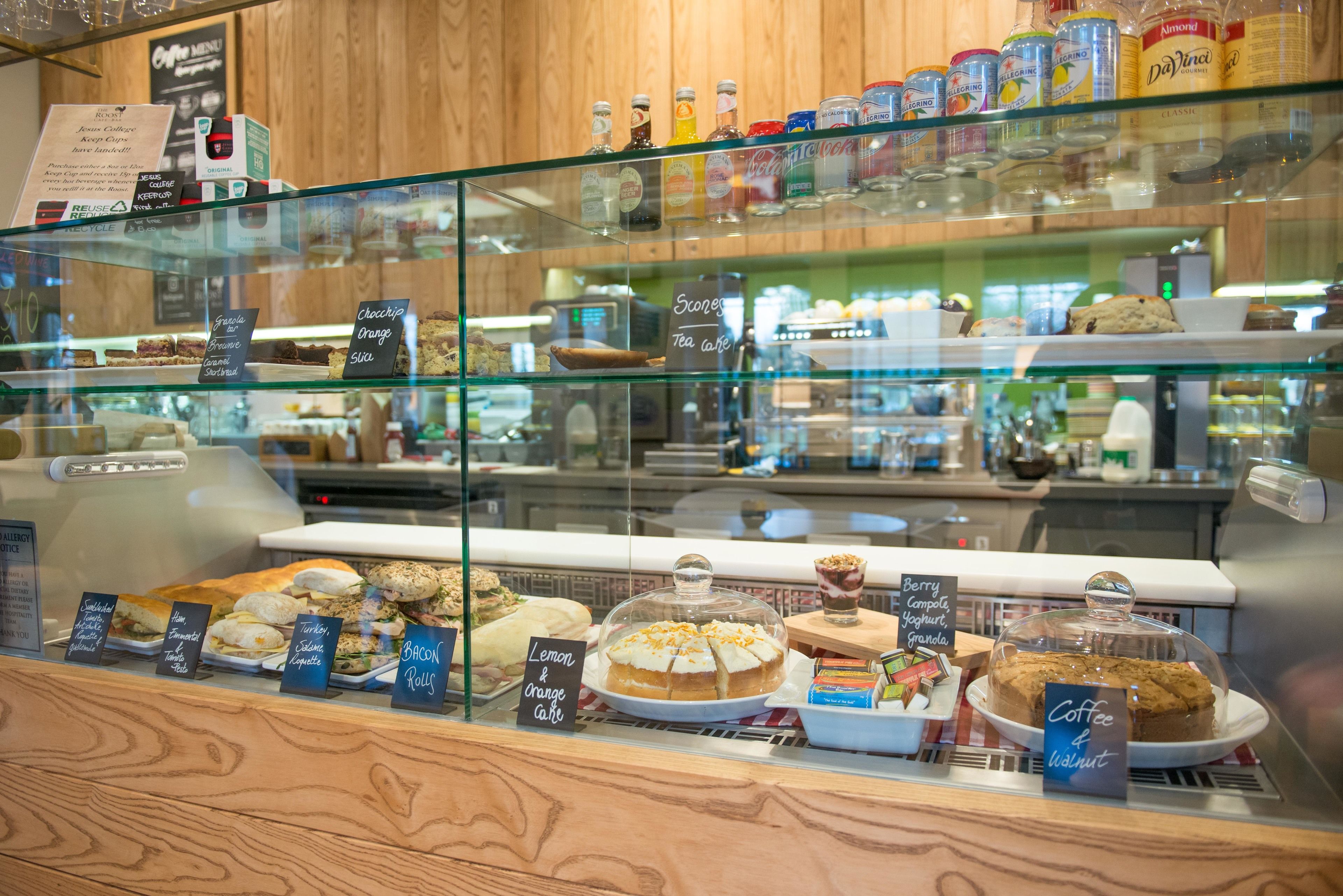 Une vitrine de boulangerie remplie de diverses pâtisseries, avec une machine à café en arrière-plan.