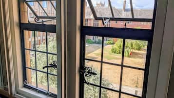 A window with a metal grid design and a lock mechanism.