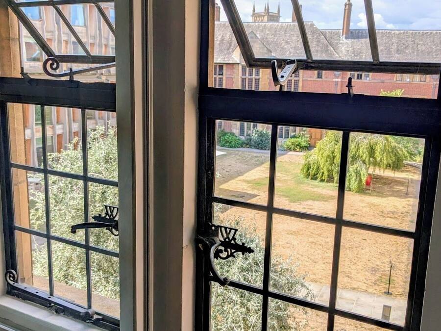 A window with a metal grid design and a lock mechanism.