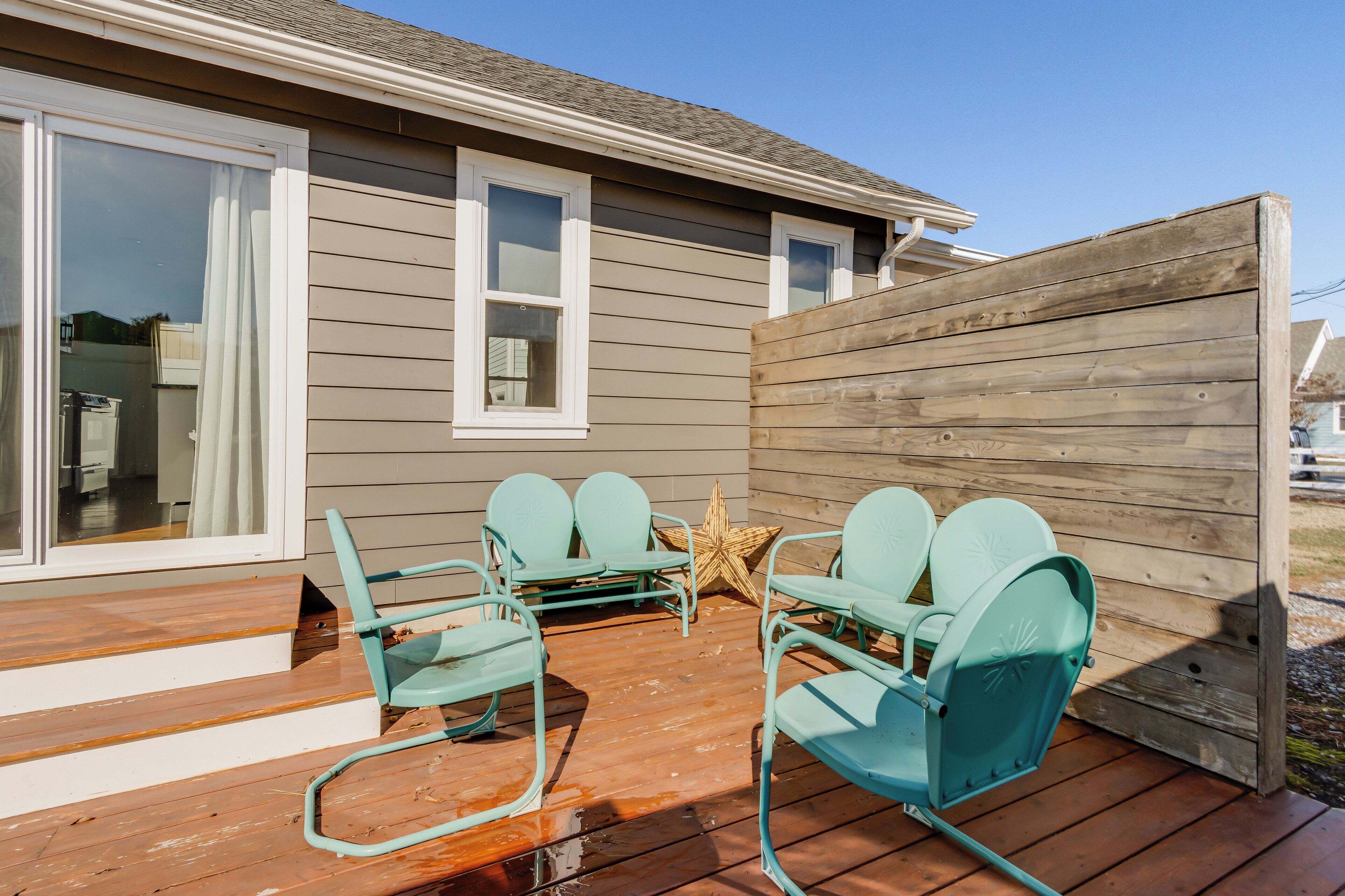 A deck with four turquoise chairs and a star decoration.