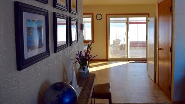 A living room with a wooden bench, a globe, and framed pictures on the wall. - Stunning view of Lake Pepin! 1/2 mile to Villa Bellezza (Pepin)