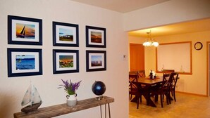 A dining area with a wooden table and chairs, a small sailboat model, and framed pictures on the wall. - Stunning view of Lake Pepin! 1/2 mile to Villa Bellezza (Pepin)