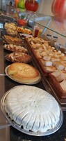 A buffet with various food items including pastries, bread, and a large white cake.