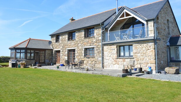 A stone house with a large porch and outdoor seating area. - Trendrennen Farm B&B (Penzance)