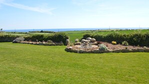 A landscaped garden with a stone border and various plants. - Trendrennen Farm B&B (Penzance)
