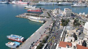 A coastal city with a marina, including large cruise ships and smaller boats. - Penthouse of light at Koukaki (Athens)