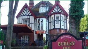 A traditional building with a sign for "Burley Inn" indicating it is a public house offering bed and breakfast and real ales. - The Burley Inn (Ringwood)