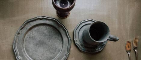 Un tavolo con un piatto, una tazza e due forchette.