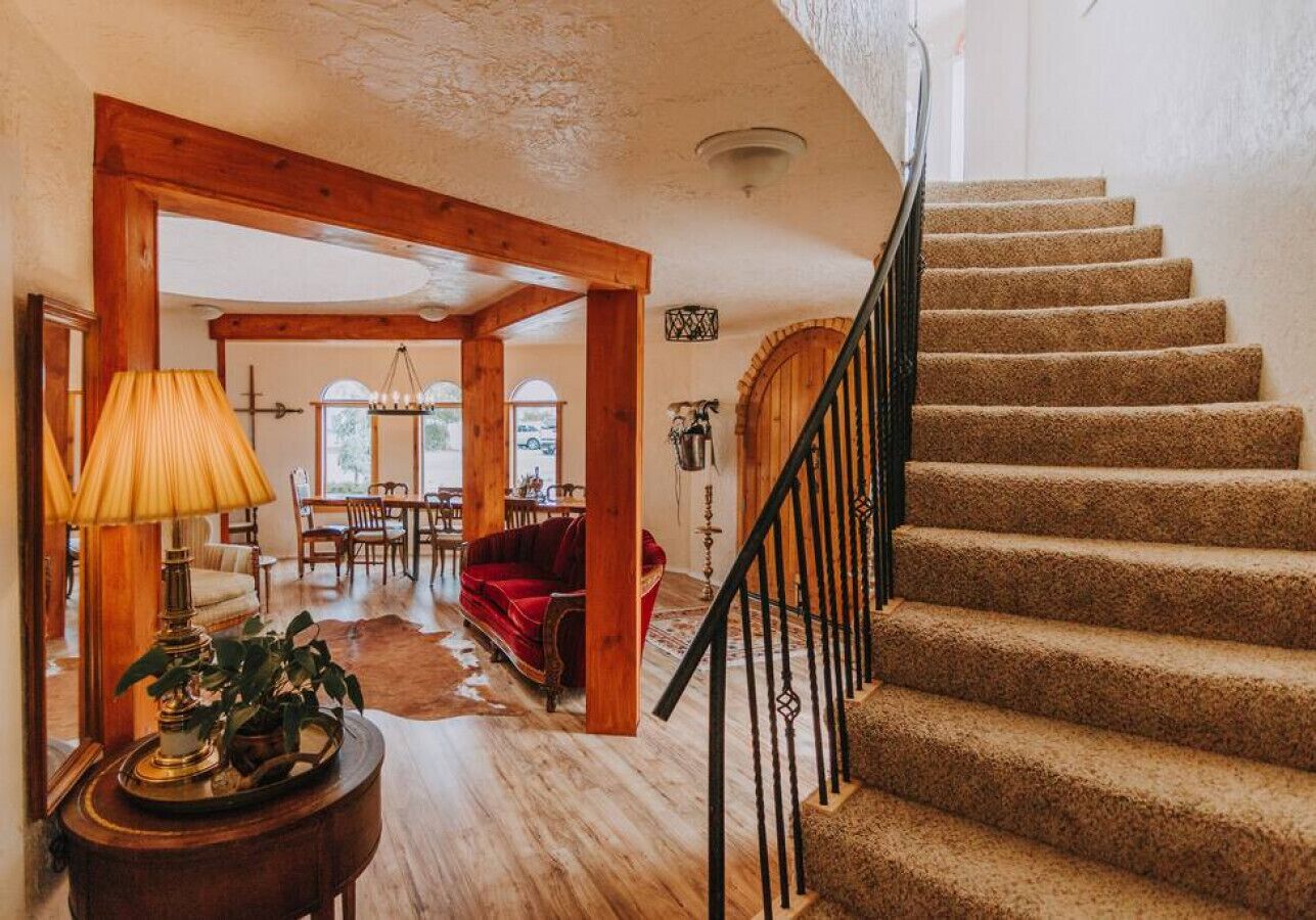 Una escalera con peldaños alfombrados y barandilla de madera.