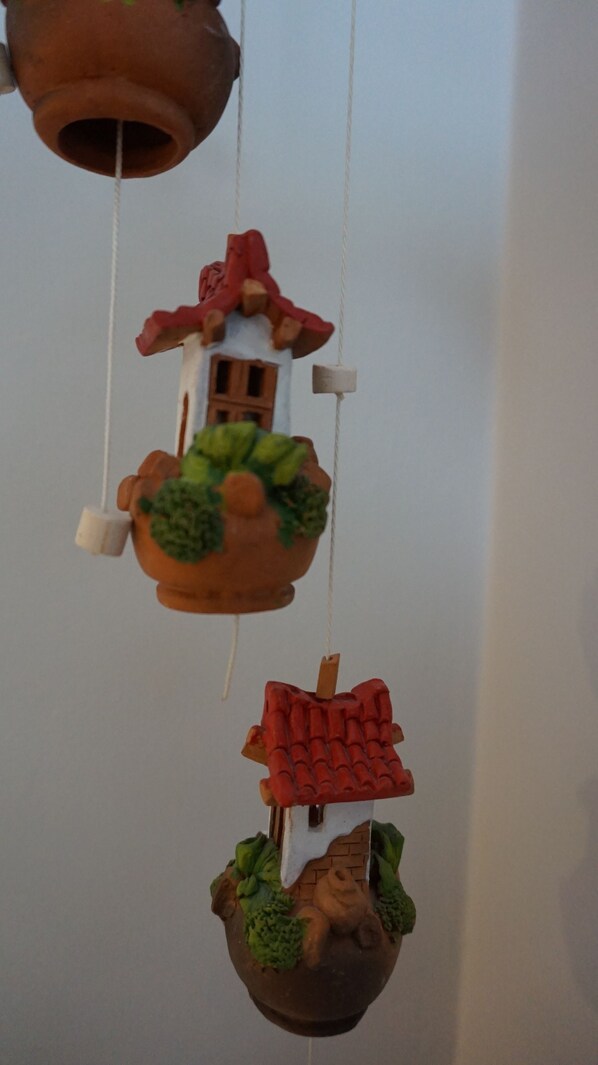 A hanging decoration with a house and a tree. - Troll's cosy apartment (Vestmannaeyjar)