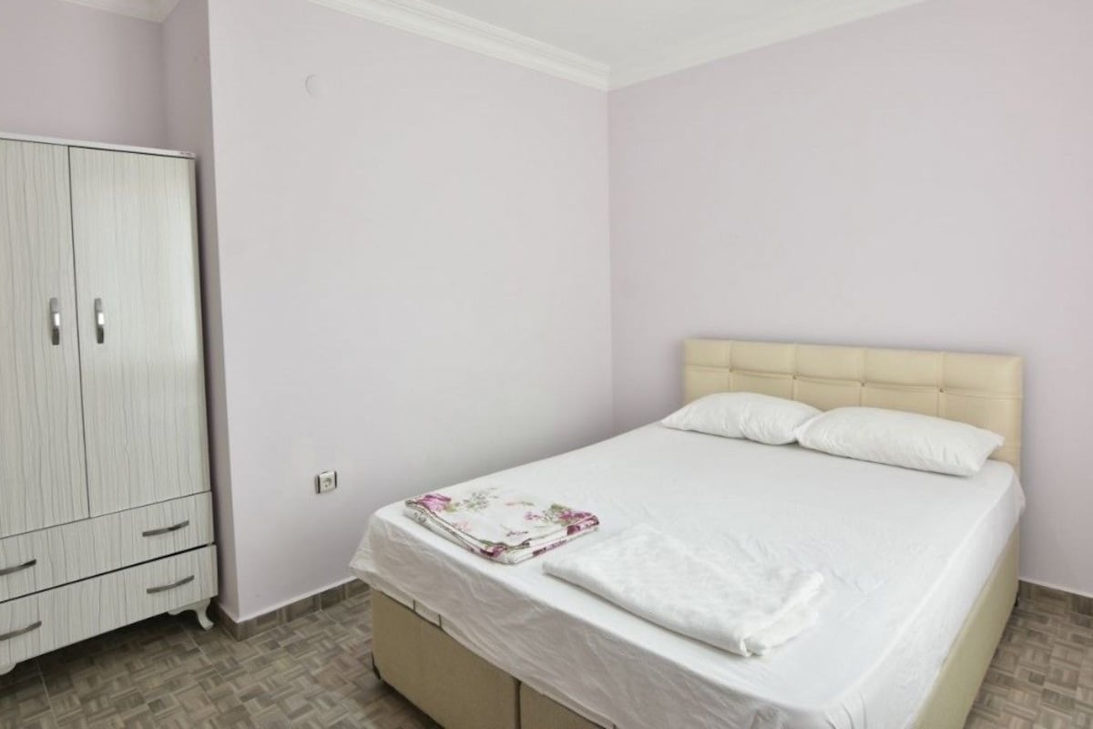 Ein Schlafzimmer mit einem Bett, einem Kleiderschrank und einem kleinen Schrank.