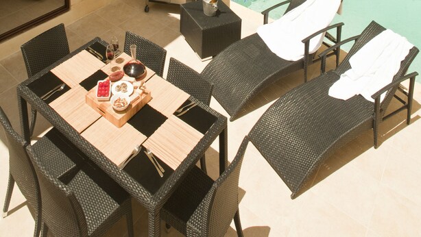 An outdoor patio with a pool, dining table, chairs, and a grill. - Serkuzan (Xaghra)