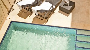 A pool area with lounge chairs, a barbecue grill, and a dining table with chairs. - Serkuzan (Xaghra)