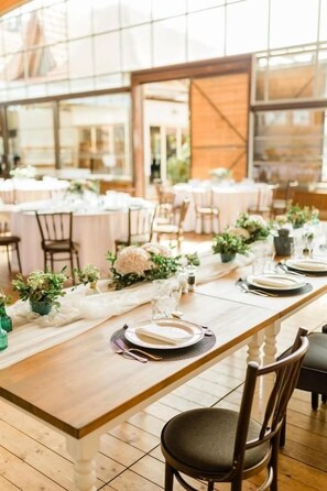 A long dining table set with white tablecloths, plates, and cutlery, surrounded by chairs. - Pension Zwicker (Lubotice)