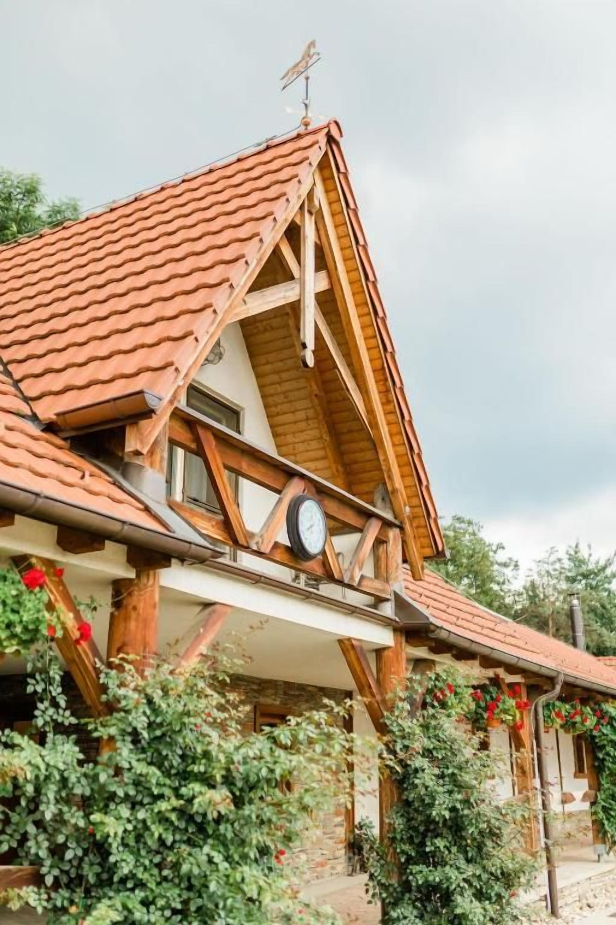 A traditional chalet with a sloped roof, wooden beams, and a visible clock.