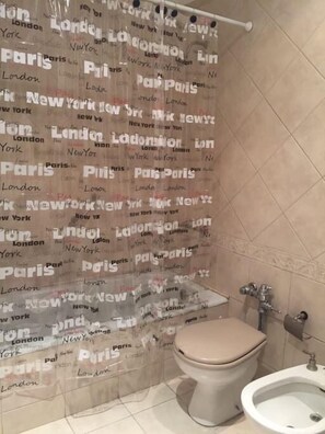 Un bagno con WC, bidet e tenda della doccia con nomi di città.