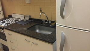 A kitchen with a gas stove, sink, and white cabinets. - Incredible Rodriguez Pena (Buenos Aires)