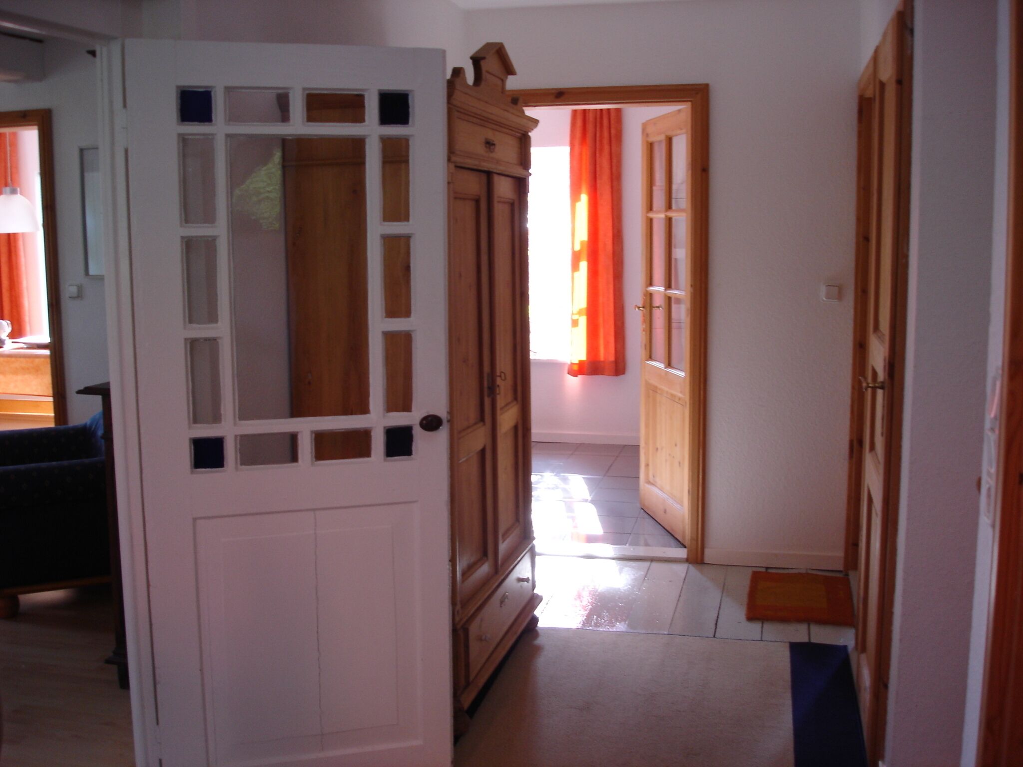 A hallway with wooden doors and a tiled floor.