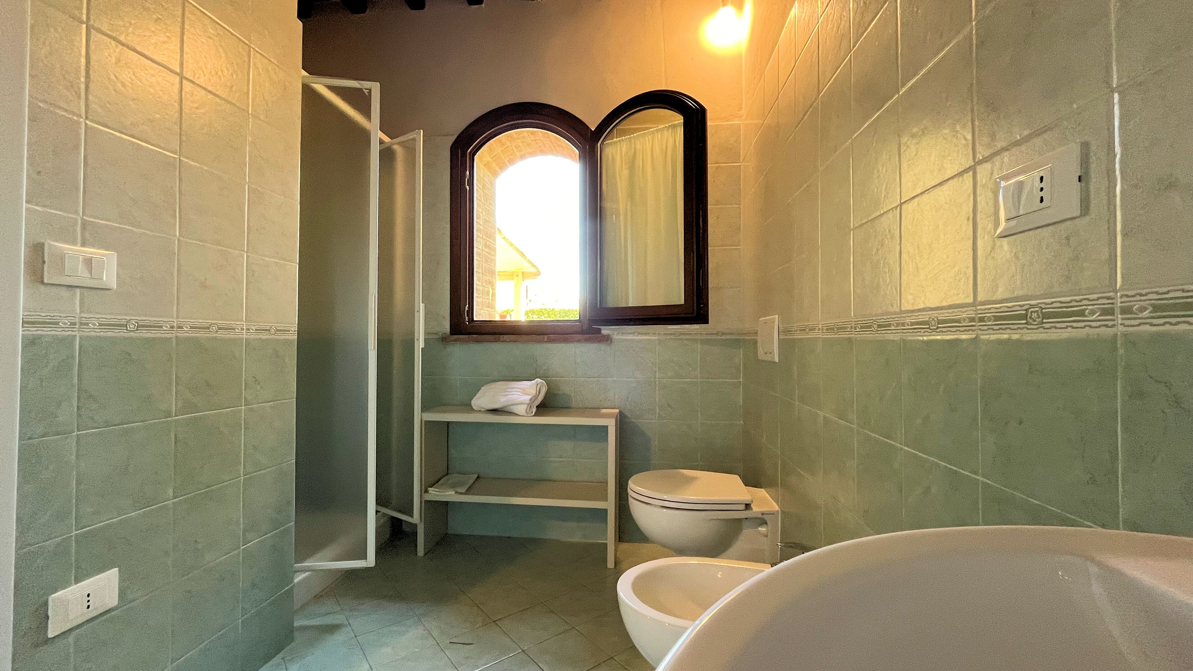 A bathroom with a shower, toilet, and sink.
