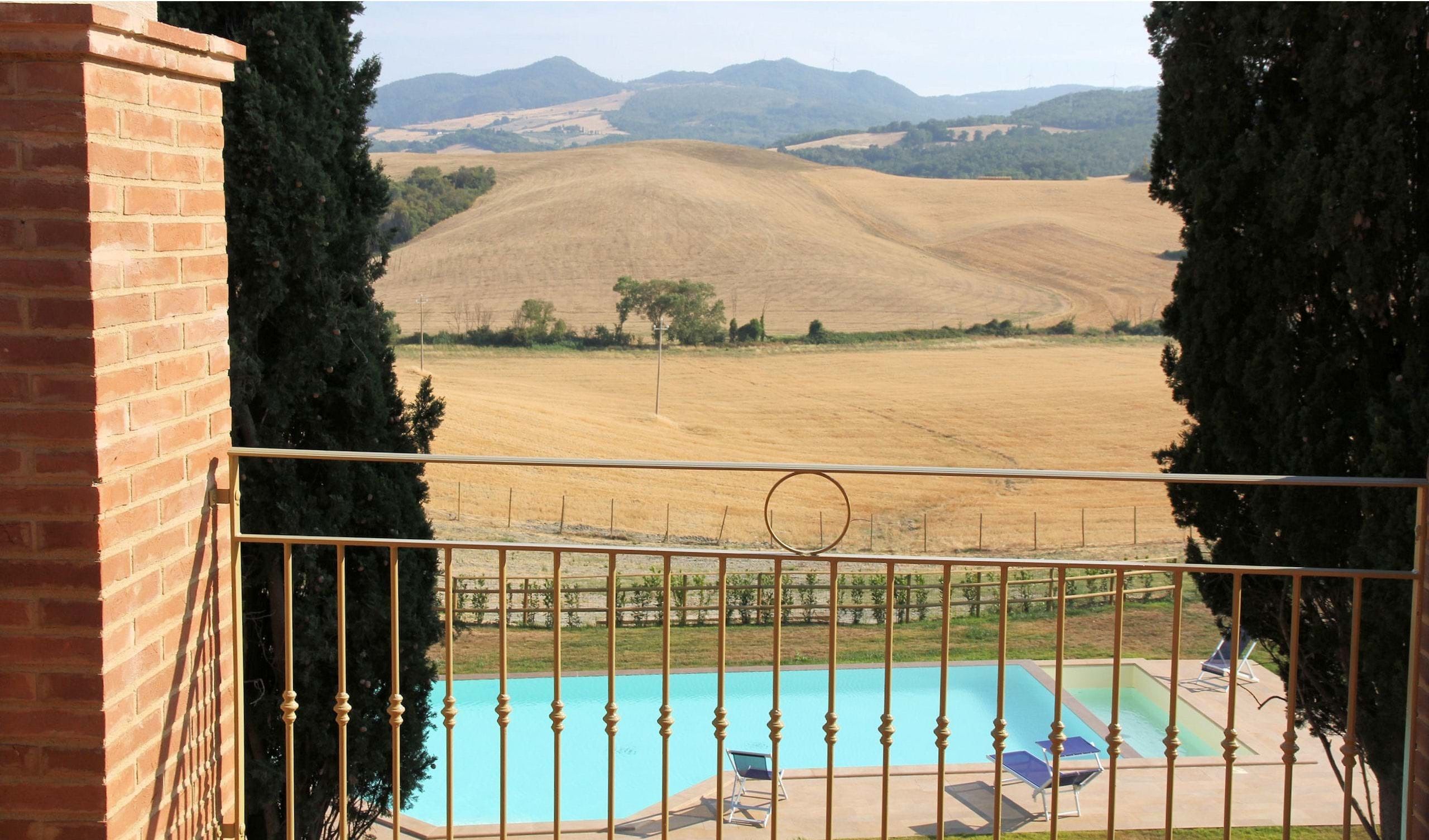 Una piscina con vista su un paesaggio collinare.