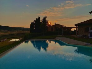 A swimming pool with a clear view of the sunset and surrounding landscape. - Borgo del Silenzio (Lajatico)