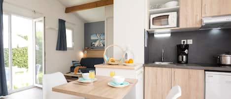 Una cocina moderna con armarios de madera, una mesa de comedor con sillas y vistas al exterior.
