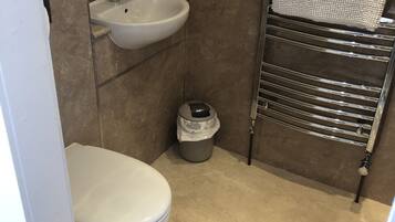 A small bathroom with a toilet, sink, and towel rack.