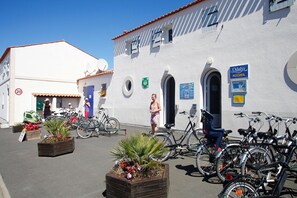 Un immeuble à la façade blanche, avec une porte bleue et une enseigne sur laquelle on peut lire « Odalys ACCUEIL ».
