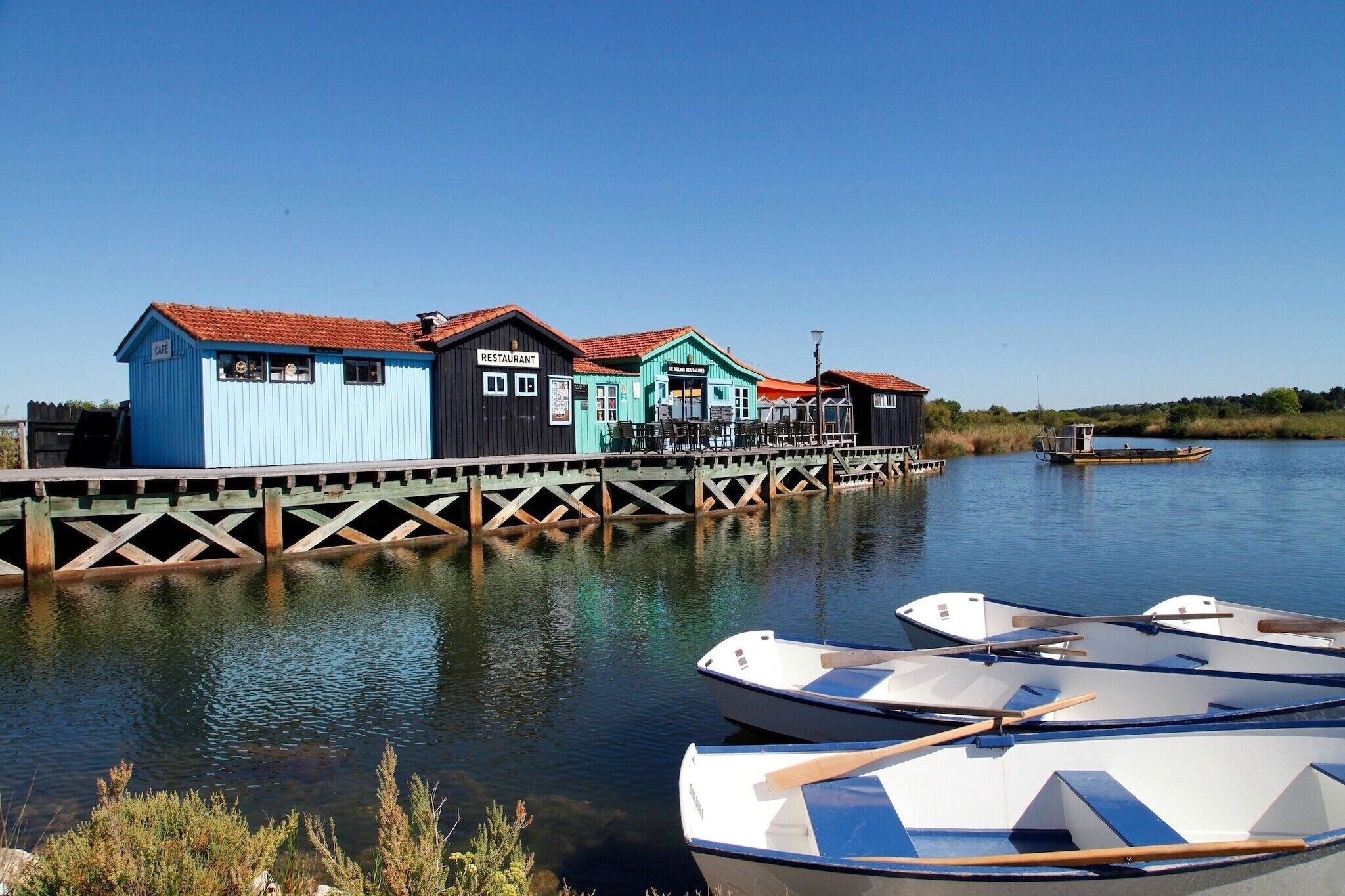 A waterfront property with a cafe, restaurant, and a pier extending into the water.