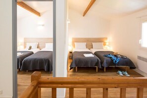 Une chambre d’hôtel avec deux lits, un plafond en bois et une fenêtre.