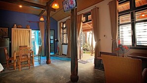 Una habitación con techo de madera, un ventilador y vistas al exterior.
